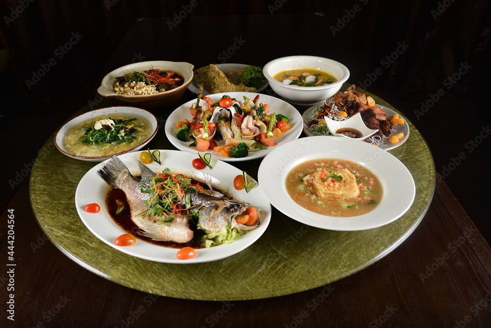 asian restaurant premium banquet cafe halal chinese menu in set with grouper fish, pork meat, fried vegetables, bean curd tofu, seafood soup and appetiser on gold dining table asian restaurant premium banquet cafe halal chinese menu in set with grouper fish, pork meat, fried vegetables, bean curd tofu, seafood soup and appetiser on gold dining table