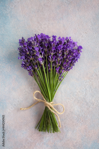 Bouquet of lavender flowers tied with rope on colored decorative plaster background
