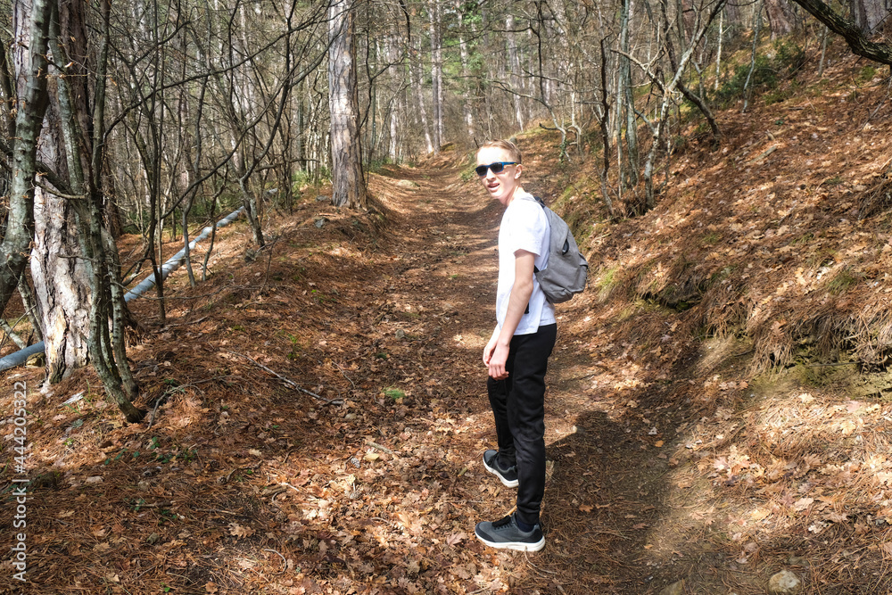 Young boy with gray backpack in the forest Young boy with gray backpack in the forest