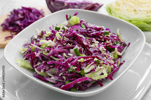Plate with tasty cabbage salad on table