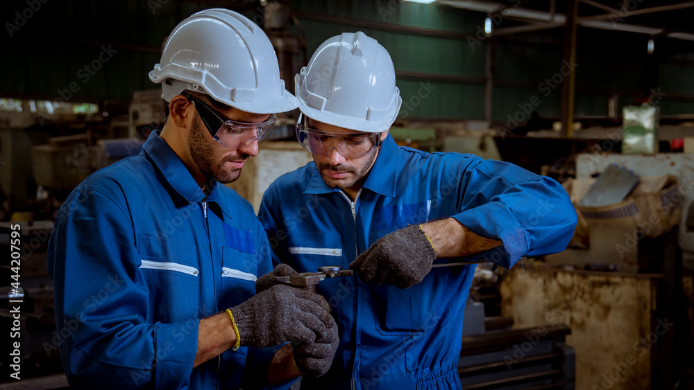 The Industry engineering wearing safety uniform control operating lathe grinding machine working in industry factory. The Industry engineering wearing safety uniform control operating lathe grinding machine working in industry factory.
