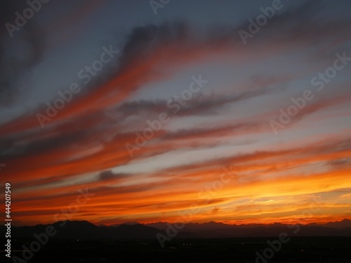 colorful summer sunset with wispy clouds over the front range of the colorado rocky mountains, as seen from broomfield, colorado 
