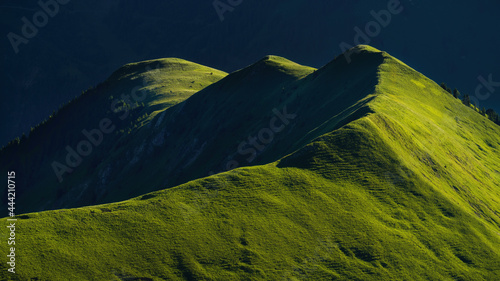 Gartner Berg at sunrise, with early morning light on grass fields on top of the mountain