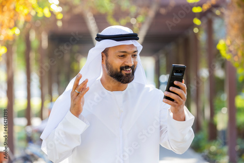 Middle Eastern Arab Emirati Vlogger holding mobile phone photo