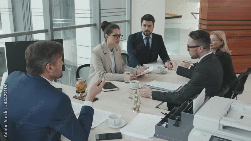 Team of professional attorneys having heated discussion or dispute during table meeting in office