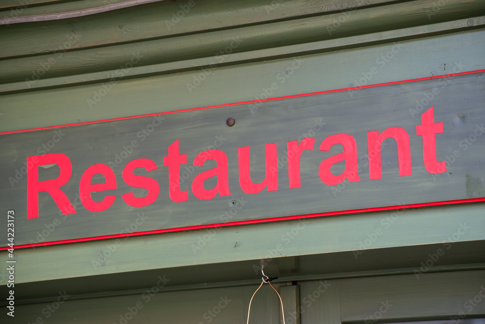Closeup of restaurant sign on building facade in the street Closeup of restaurant sign on building facade in the street