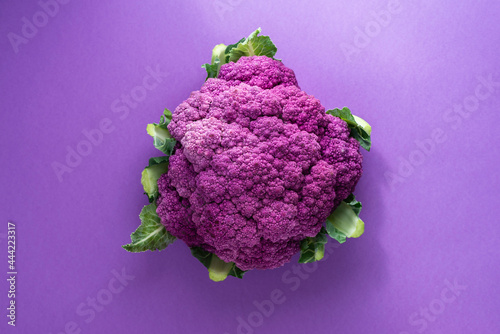 Fresh purple cauliflower over a purple background, top view photo