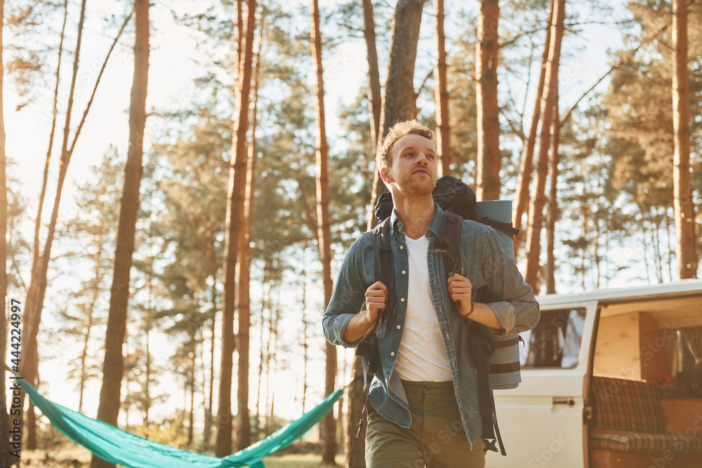 Near car and camp. Man is traveling alone in the forest at daytime at summer
