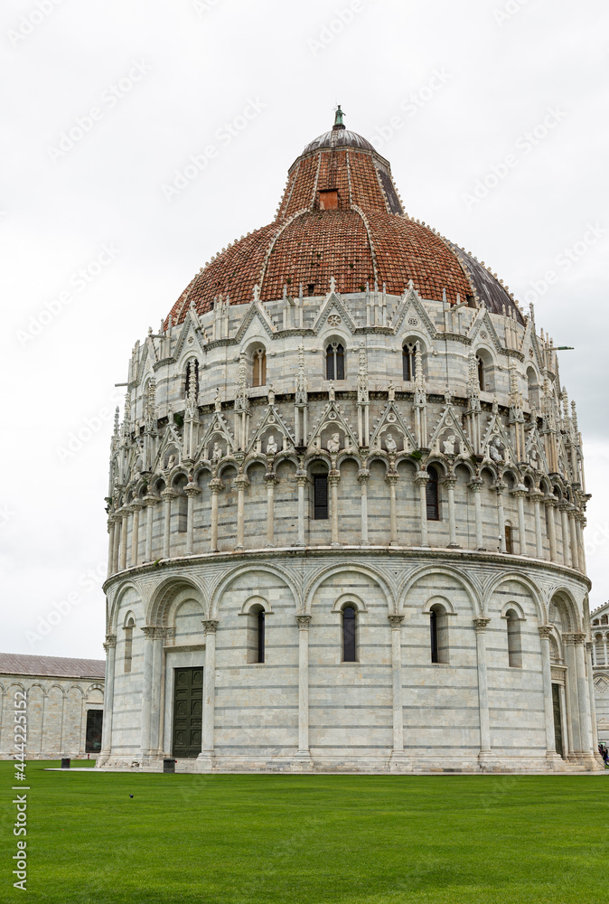 View to the baptistery near leaning Tower and cathedral of Pisa, located on Piazza dei Miracoli (Square of Miracles)