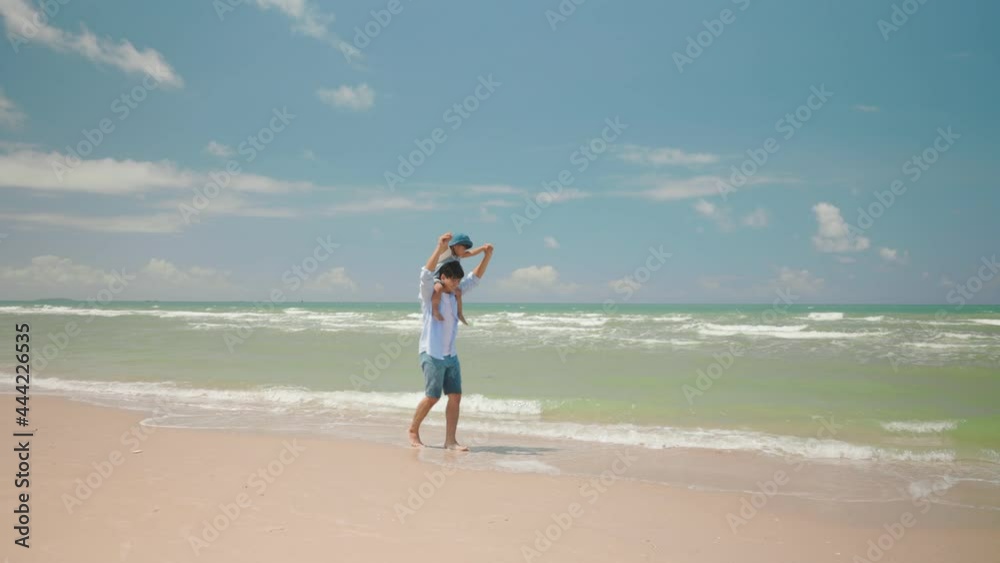 Asian son sitting on his father neck at the beach on the summer day. Asian son sitting on his father neck at the beach on the summer day.