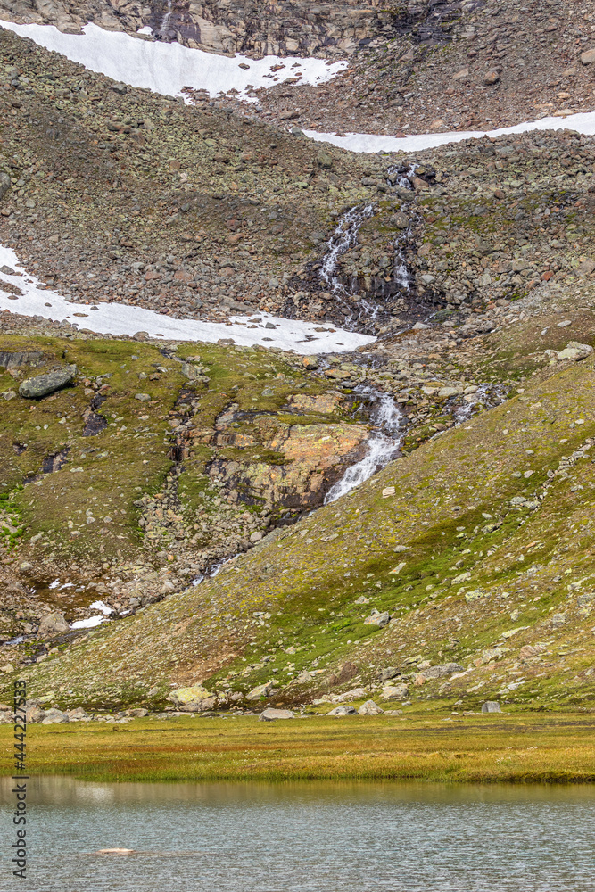 Waterfall that flows into a mountain lake Waterfall that flows into a mountain lake