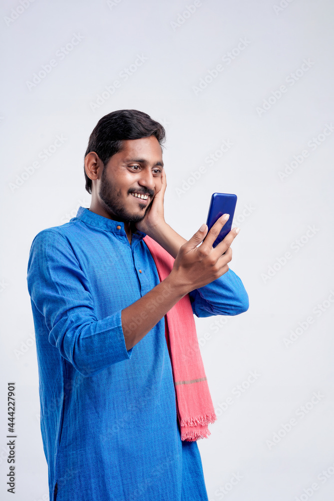 Young indian farmer using smartphone on white background. Young indian farmer using smartphone on white background.
