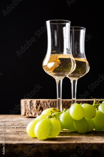 Quadro su tela Italian golden grappa drink on black background