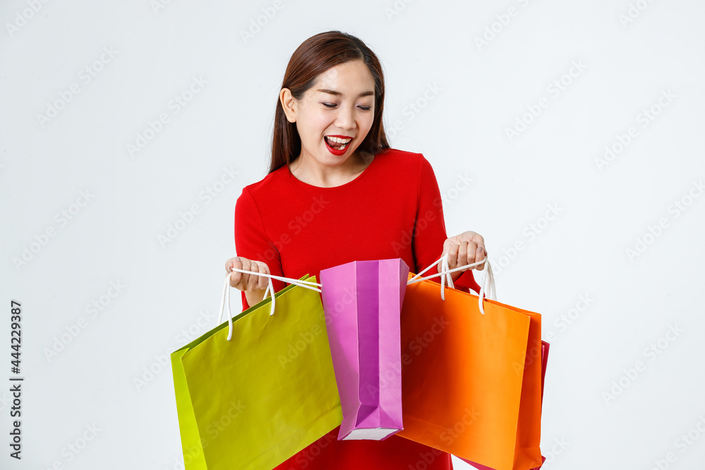 Happy ethnic woman looking in shopping bags in studio Happy ethnic woman looking in shopping bags in studio