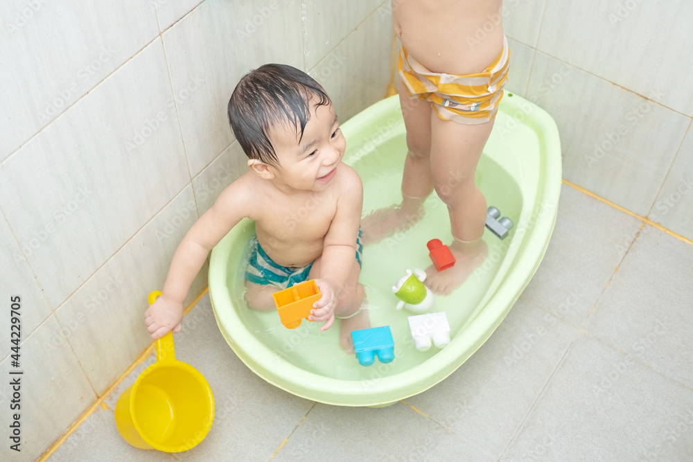 two little boys take a bath and play together two little boys take a bath and play together