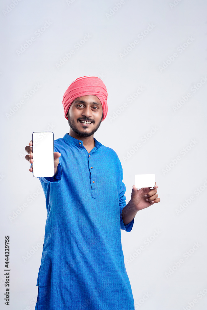 Young indian farmer showing card and smartphone on white background. Young indian farmer showing card and smartphone on white background.