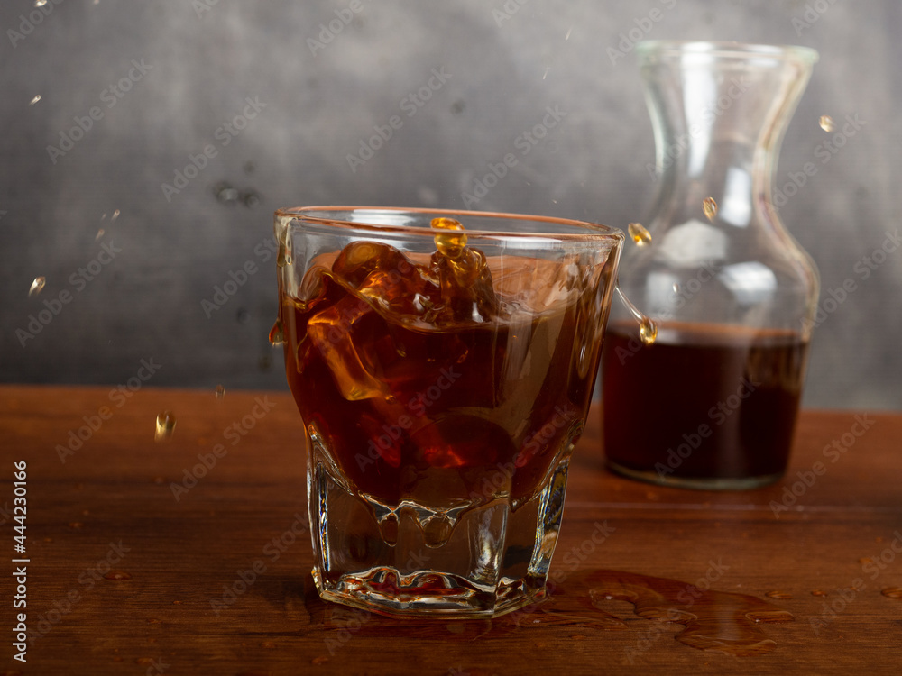 A cup of iced coffee on a wooden table A cup of iced coffee on a wooden table
