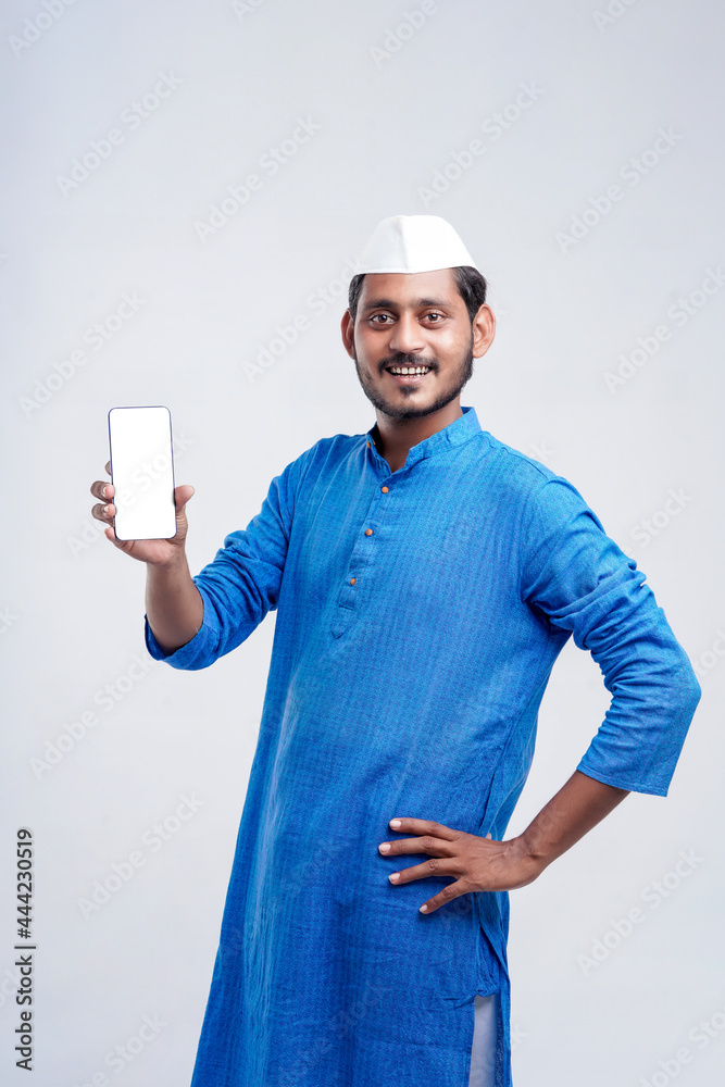Young indian farmer showing smartphone and giving expression on white background. Young indian farmer showing smartphone and giving expression on white background.