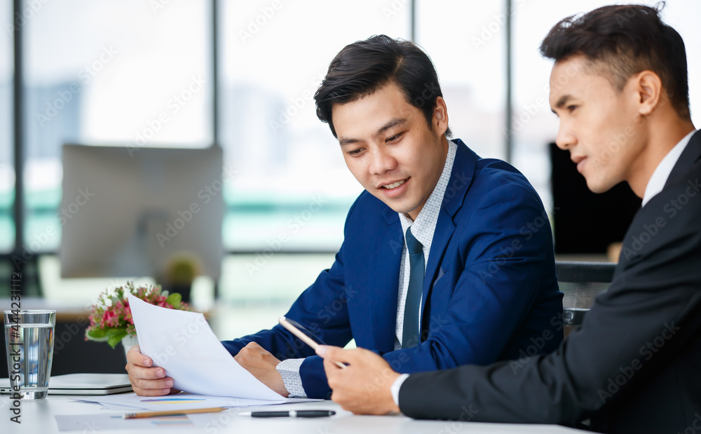 Fototapeta premium Cheerful ethnic businessmen discussing project in office