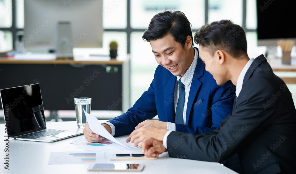 Cheerful businessmen reading documents in workplace Cheerful businessmen reading documents in workplace