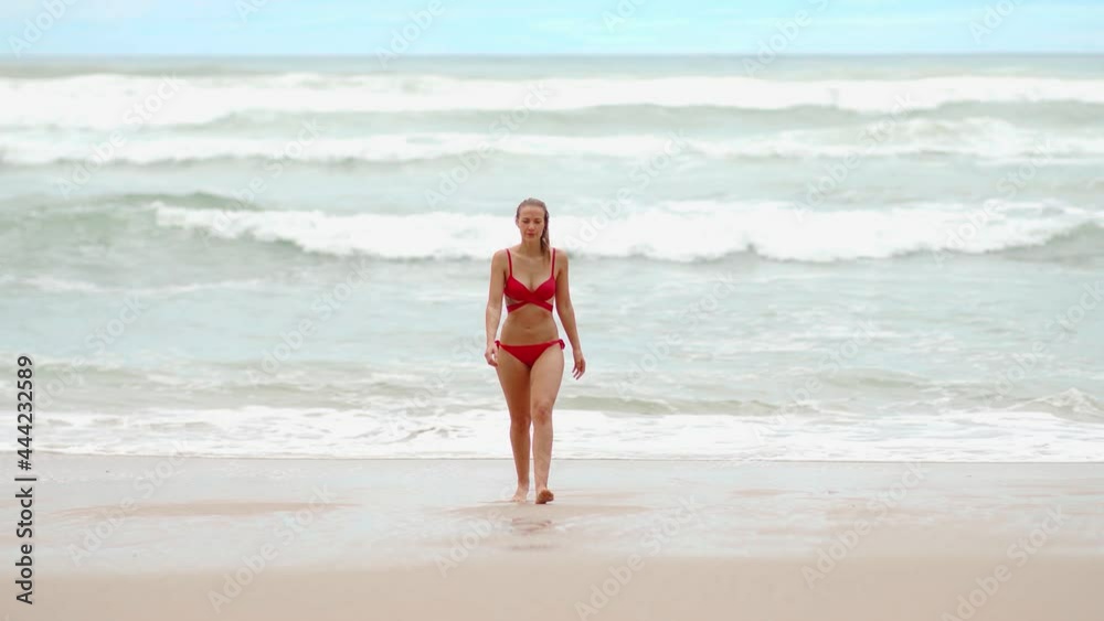 Sexy woman at the ocean walking at the beach - extreme slow motion shot - people photography Sexy woman at the ocean walking at the beach - extreme slow motion shot - people photography