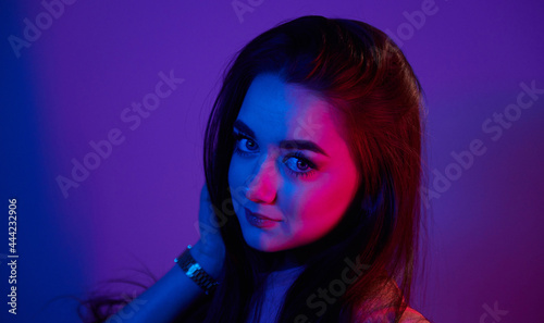 Portrait of fashionable young woman that standing in the studio with neon light