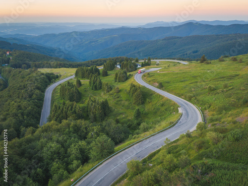 Drone follows Big truck delivering on asphalt mountain road