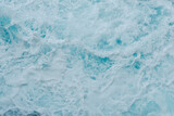 Vivid blue sea water moving and creating white foam. For backgrounds and backdrops. Concepts of purity, change, resistance