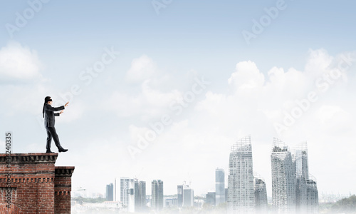 Konstfotografi Danger and risk concept with businessman making step from edge
