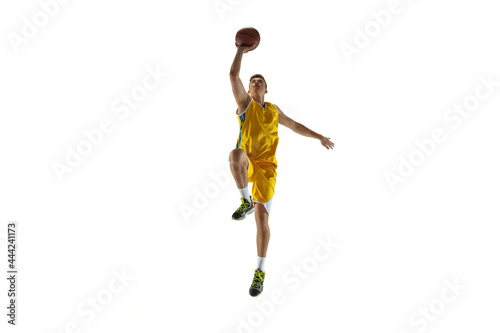 Full length portrait of a basketball player with a ball isolated on white studio background. Advertising concept. Fit Caucasian athlete jumping with ball.