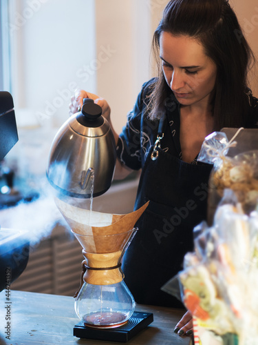 Professional barista a young woman prepares coffee in kemex, a method of making espresso photo