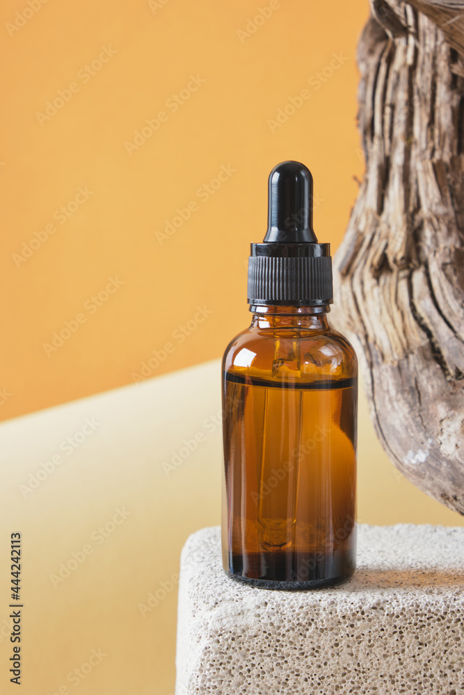 brown glass bottle with a pipette on a concrete podium on a wooden driftwood background, brown background brown glass bottle with a pipette on a concrete podium on a wooden driftwood background, brown background