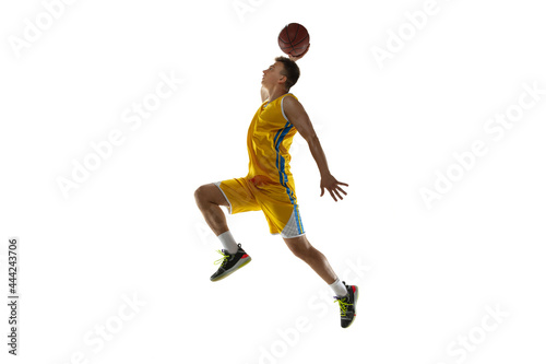 Full length portrait of a basketball player with a ball isolated on white studio background. Advertising concept. Fit Caucasian athlete jumping with ball. © master1305