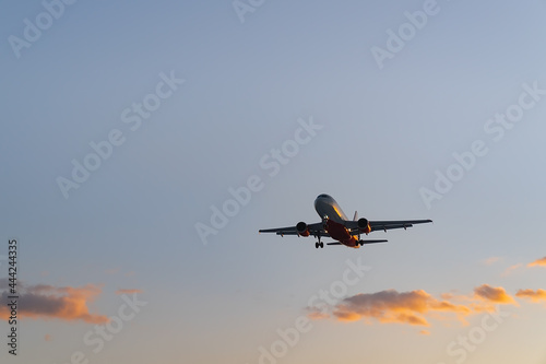 The plane comes in for landing at sunset