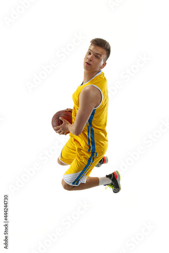 Full length portrait of a basketball player with a ball isolated on white studio background. Advertising concept. Fit Caucasian athlete jumping with ball.