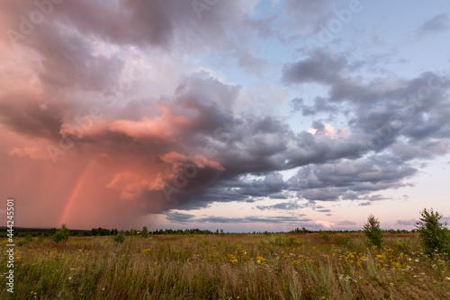 Storm clouds with a rainbow before sunset © Akokorev