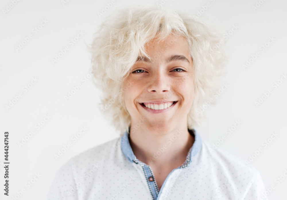 Portrait of cheerful young blond man smiling looking at camera