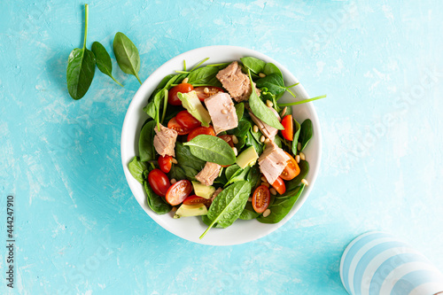 Tuna and spinach salad healthy food blue background photo