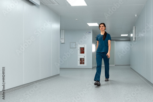 Cheerful doctor woman walks along the corridors of the clinic. © Georgii