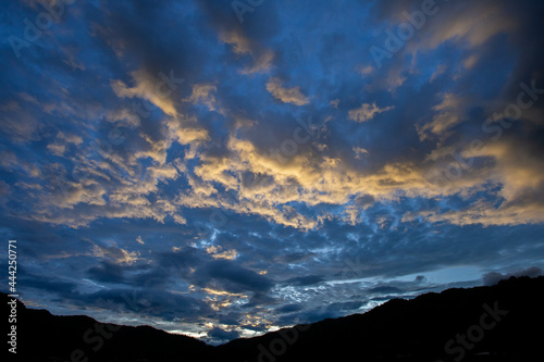 mountain scenery silhouette blue sky Yellow-orange clouds after sunset and after rain, evening. Beautiful evening sky image for the blue background.