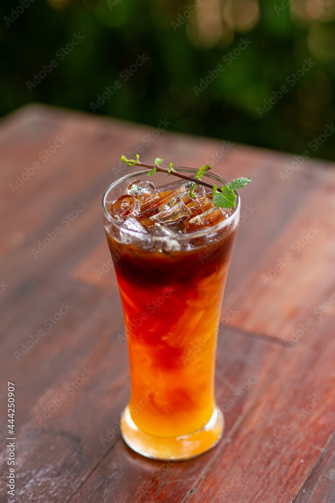 Focus only on the ice point in a glass of iced coffee mixed with orange juice. Looks delicious, smells fresh. Refreshing coffee mixed with fruit juice drinks in a coffee shop. Focus only on the ice point in a glass of iced coffee mixed with orange juice. Looks delicious, smells fresh. Refreshing coffee mixed with fruit juice drinks in a coffee shop.