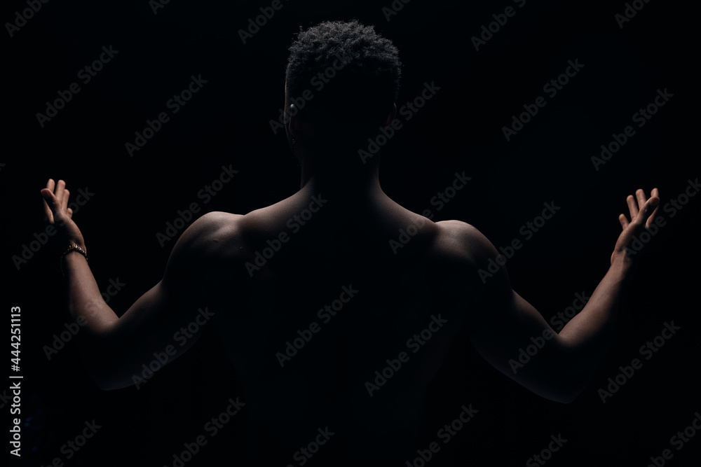 photograph of a dark-skinned young guy with an illuminated portrait. Photo with outstretched arms photograph of a dark-skinned young guy with an illuminated portrait. Photo with outstretched arms