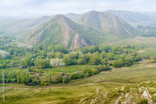 View of the spring mountain landscape through the misty haze. Andreevskie Cones. Photo taken near Andreevka village, Orenburg region, Russia