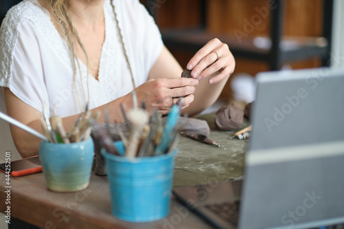 artisan pottery tutor in art studio. woman ceramist teaches an online lesson or leads a video master class on creating ceramic products