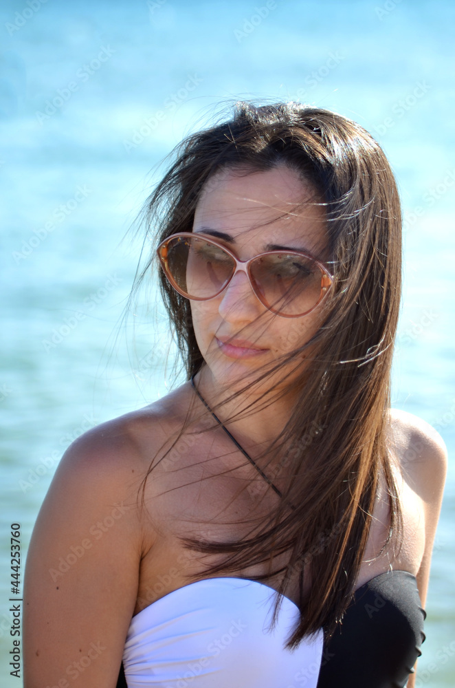 Portrait of a girl in sunglasses on the background of the sea Portrait of a girl in sunglasses on the background of the sea