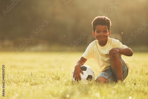 Illuminated by sunlight. African american kid have fun in the field at summer daytime © standret