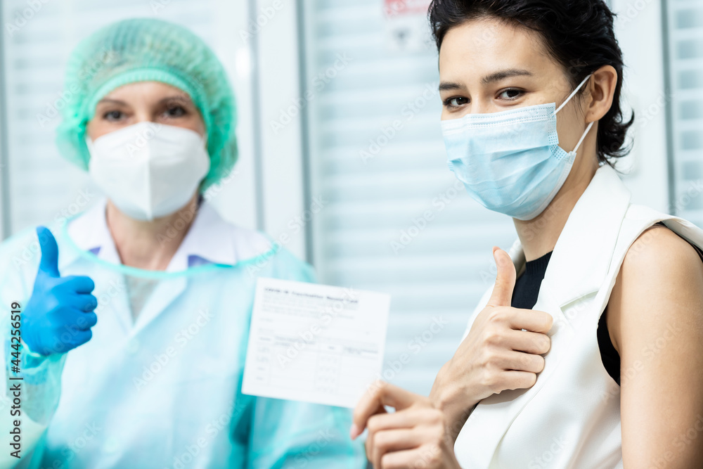 Female doctor wearing mask performs vaccination Write a vaccination record. Covid-19 hospital approves middle-aged patients from holding a vaccination record card, concept of coronavirus, vaccination Female doctor wearing mask performs vaccination Write a vaccination record. Covid-19 hospital approves middle-aged patients from holding a vaccination record card, concept of coronavirus, vaccination