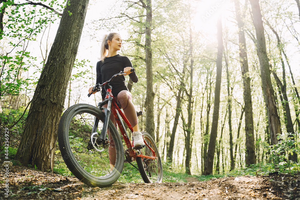 Fototapeta premium Woman riding a mountain bike in the forest