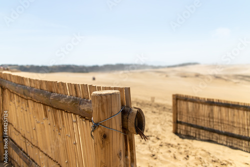 Closeup fences with blurred Tottori Sand Dunes (Tottori Sakyu) background. Dunes located near the city of Tottori in Tottori Prefecture and form the large dune system over 2.4 km in Sanin, Japan