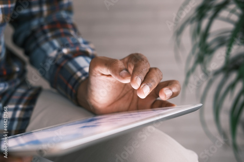 man's hand working on digital tablet at office desk, using self created chart  photo
